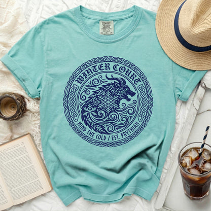 Turquoise t-shirt with dark blue "Winter Court Mind the Cold" wolf and snowflake graphic.