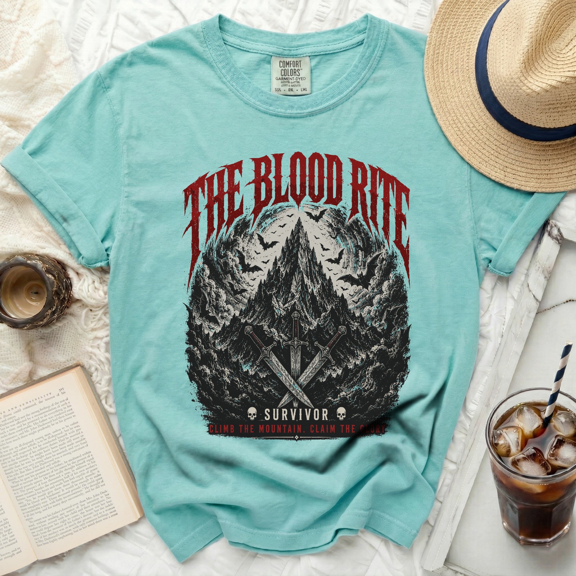 Teal t-shirt with "The Blood Rite" and mountain graphic.