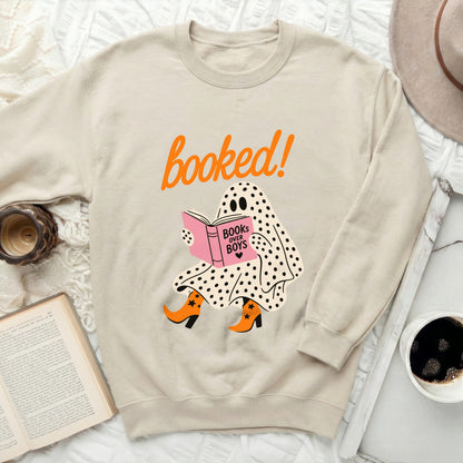 Cream sweatshirt with ghost reading "Books Over Boys" and "booked!" text.
