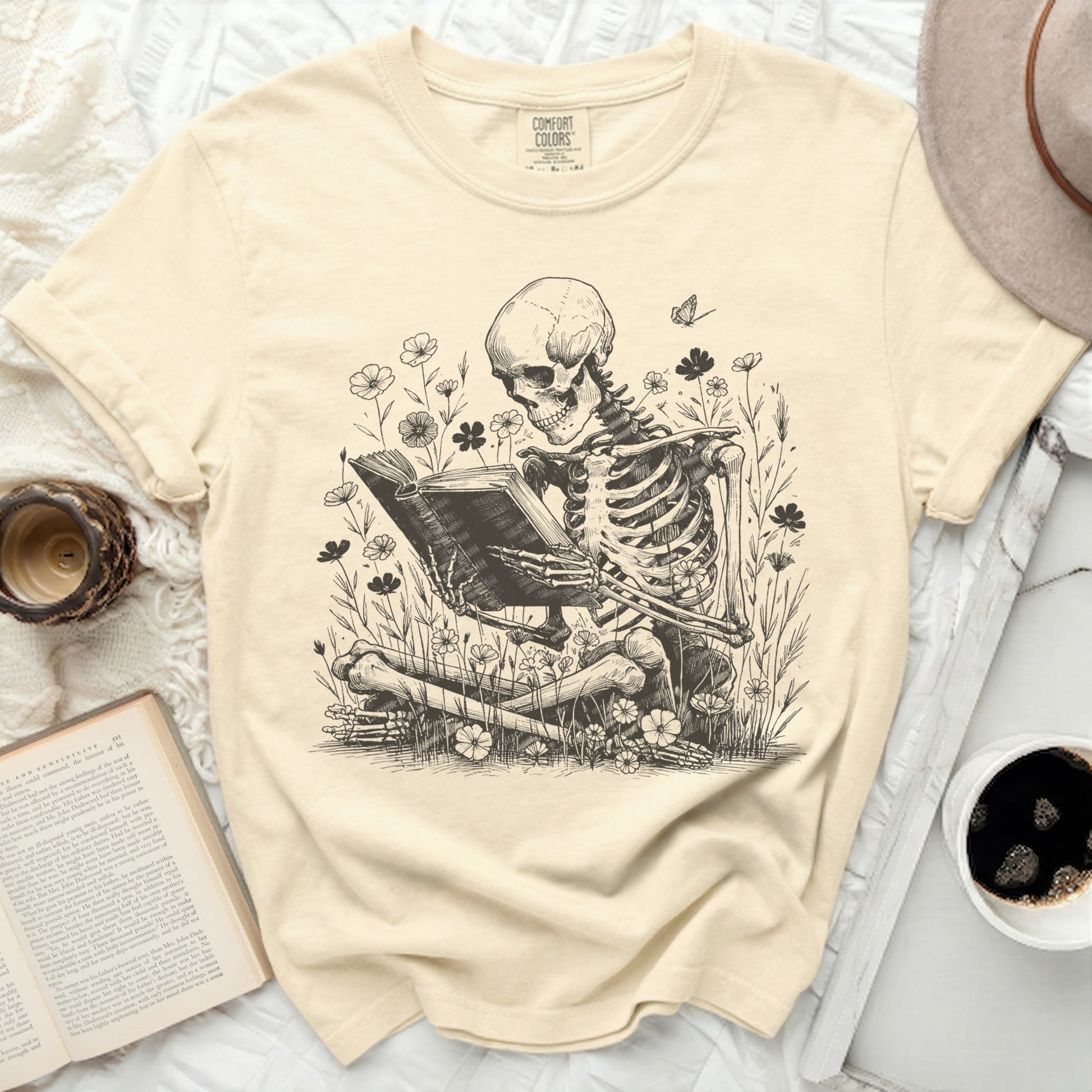 Skeleton reading a book among flowers and a butterfly.