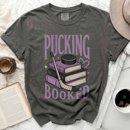 Dark gray t-shirt with "Pucking Booked" text and hockey puck on books.