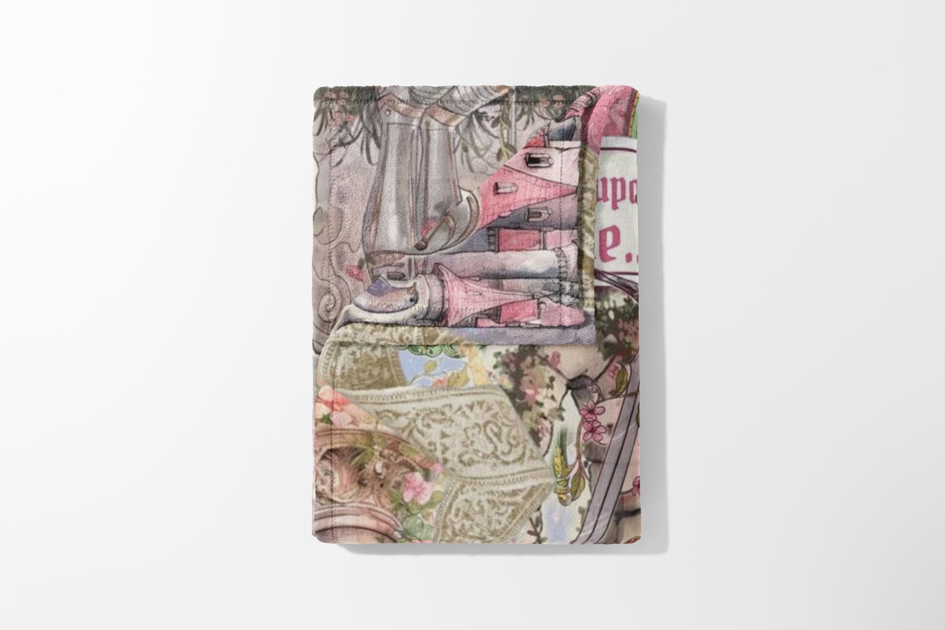 Folded blanket with a pink, gray, and tan toile-style print featuring houses and floral elements.
