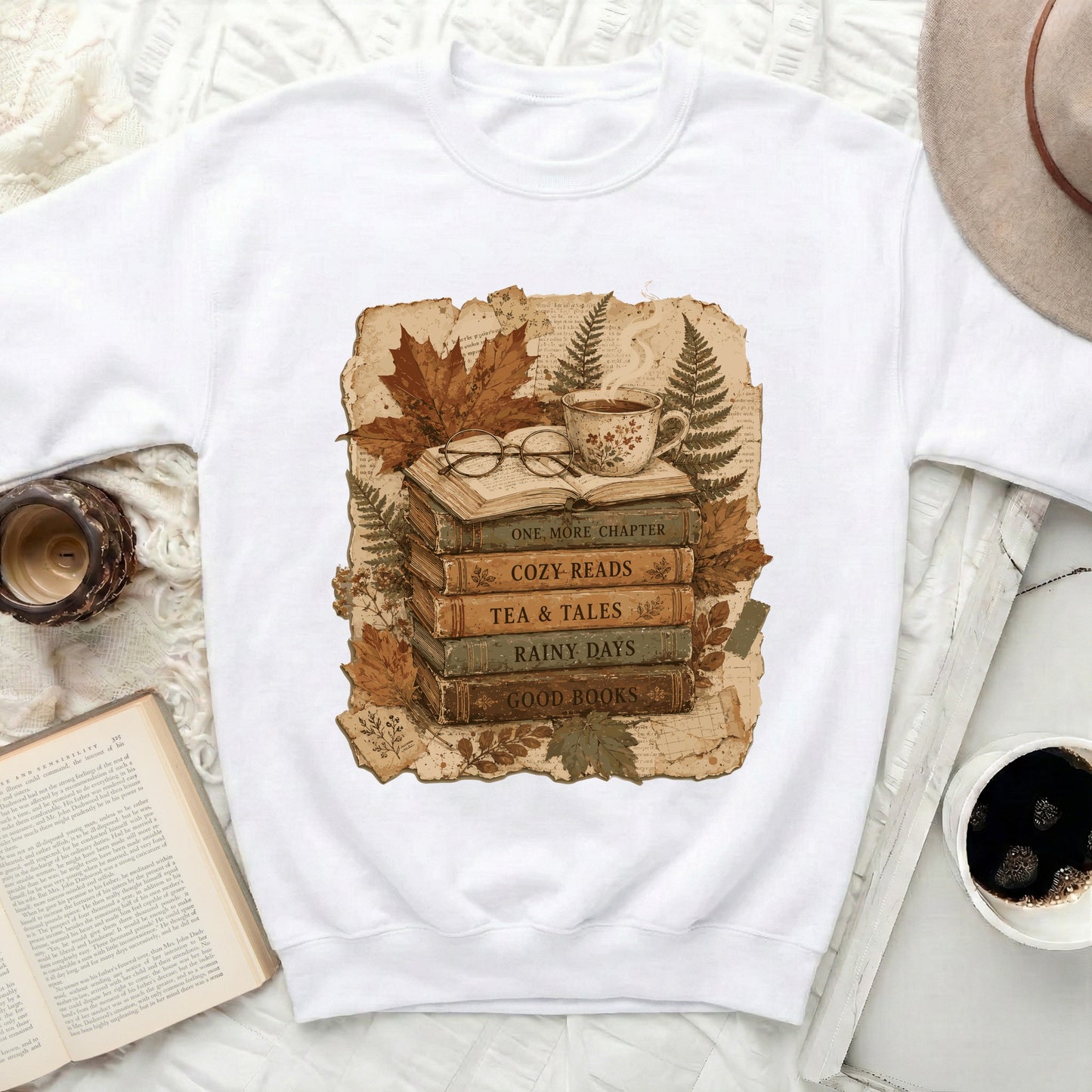 White sweatshirt with a vintage graphic of stacked books, glasses, and a cup of tea.