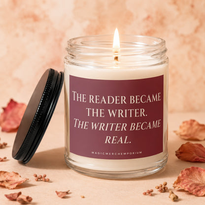 Glass candle with lit wick, featuring text: The reader became the writer. The writer became real.
