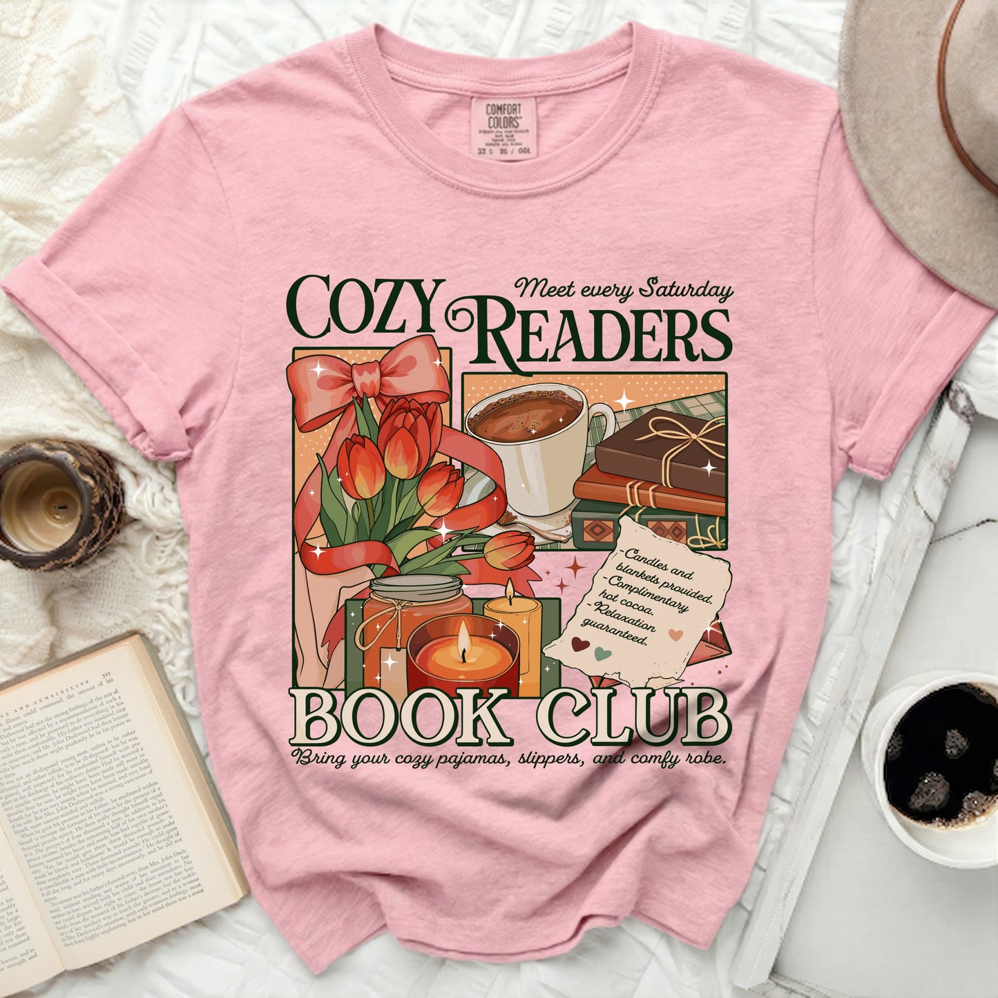 Pink t-shirt with "Cozy Readers Book Club" graphic featuring tulips, hot cocoa, books, and candles.