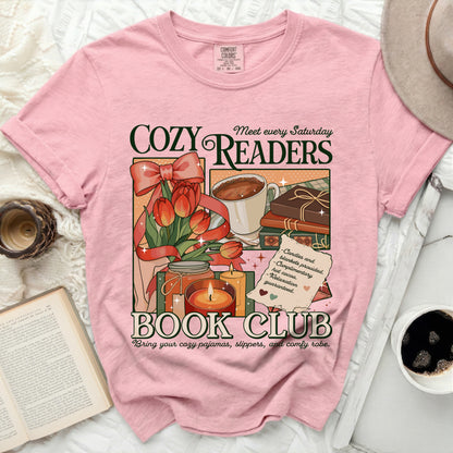 Pink t-shirt with "Cozy Readers Book Club" graphic featuring tulips, hot cocoa, books, and candles.