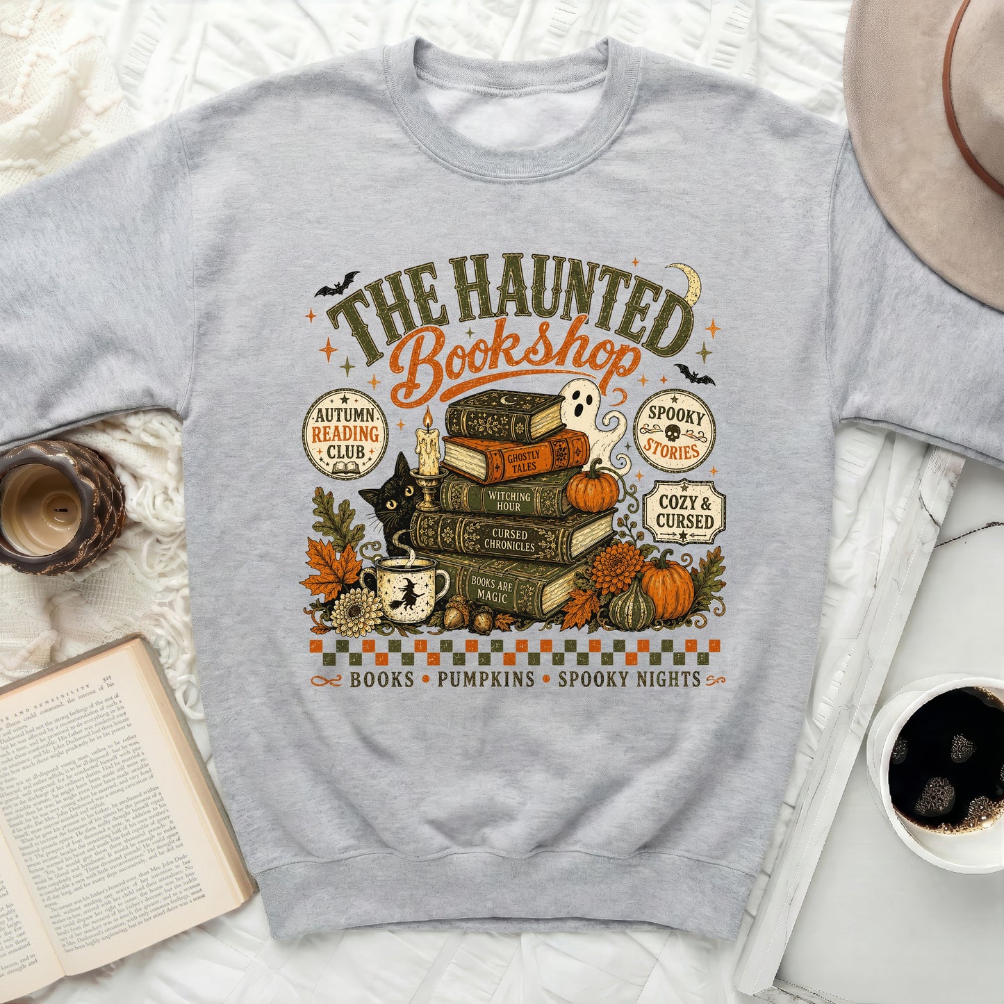 Grey sweatshirt with "The Haunted Bookshop" Halloween graphic.