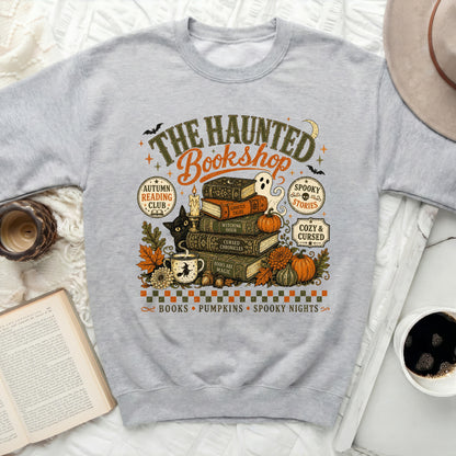 Grey sweatshirt with "The Haunted Bookshop" Halloween graphic.