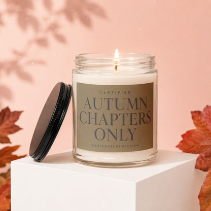 Candle with label reading "Certified Autumn Chapters Only" on a white cube.