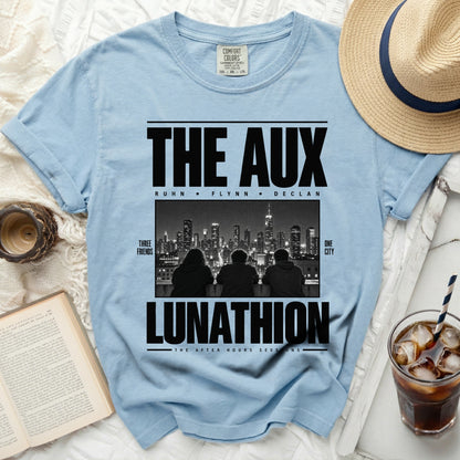 Light blue t-shirt with black text "THE AUX" and "LUNATHION" and city image.