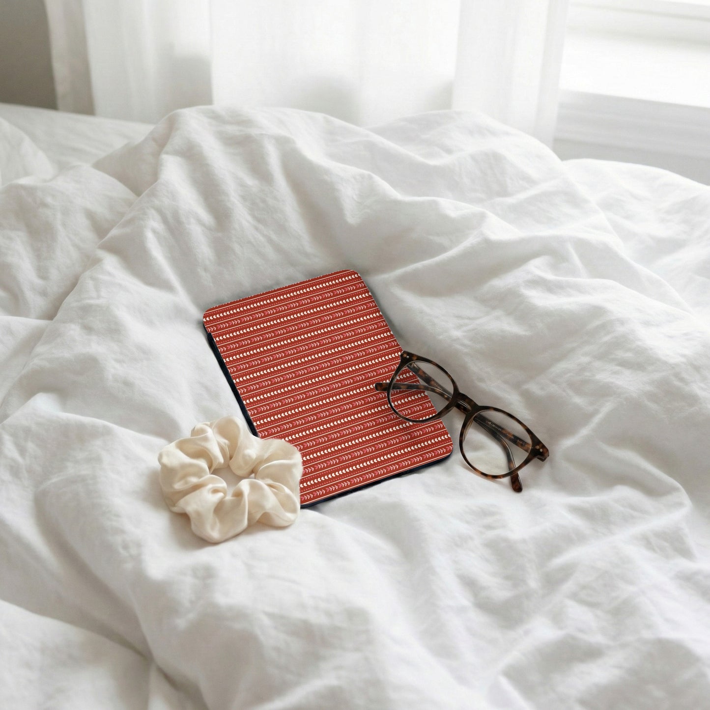 Red Patterned Tablet Cover Laying on Bedding Product