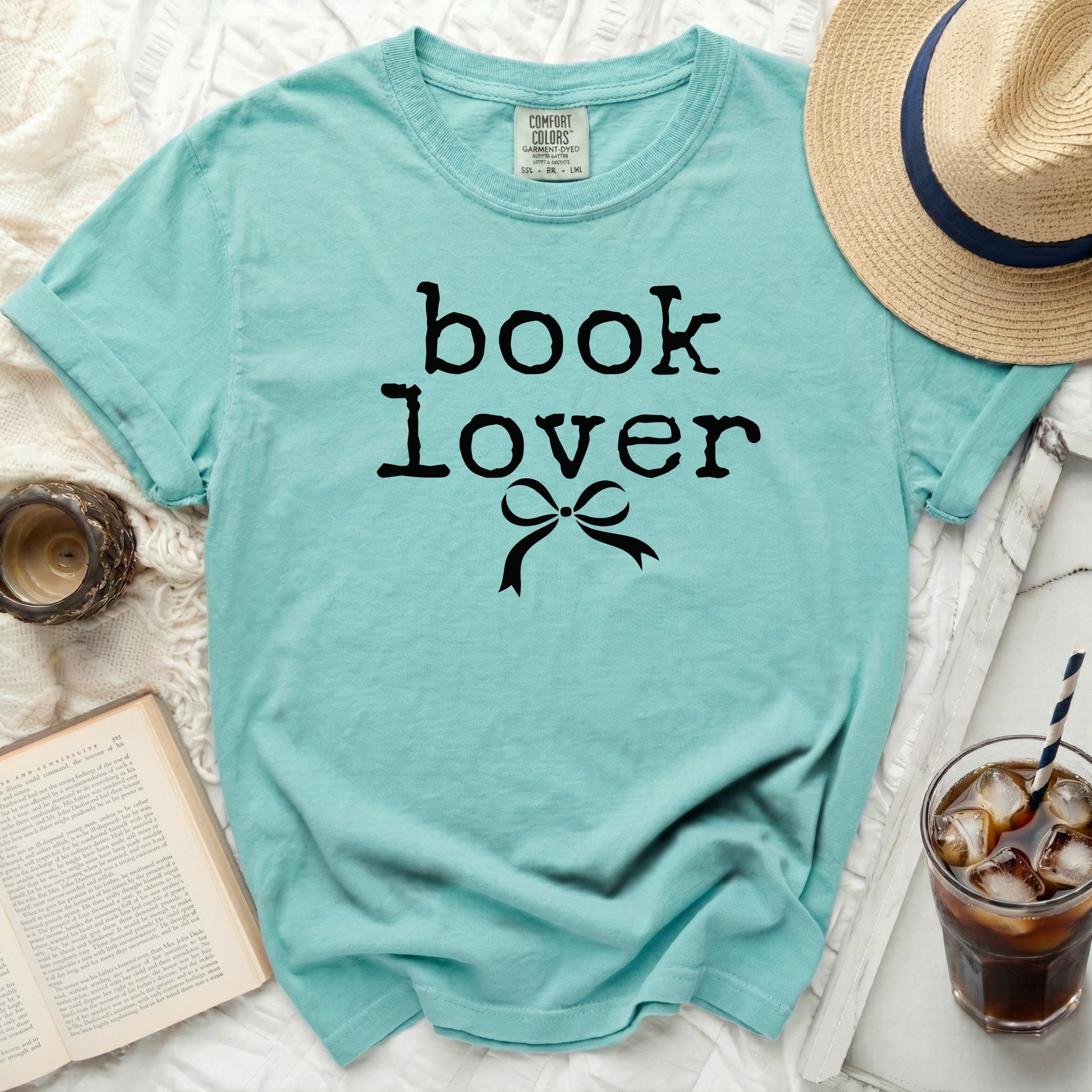 Turquoise t-shirt with "book lover" text and a bow graphic.