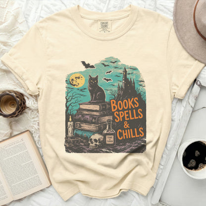 Cream t-shirt with black cat, books, skull, and "Books Spells & Chills" text.