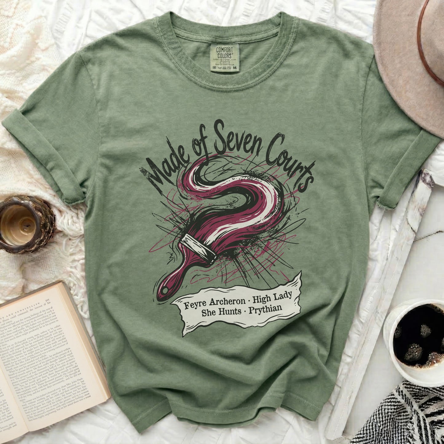 Green t-shirt with "Made of Seven Courts" and brush graphic.