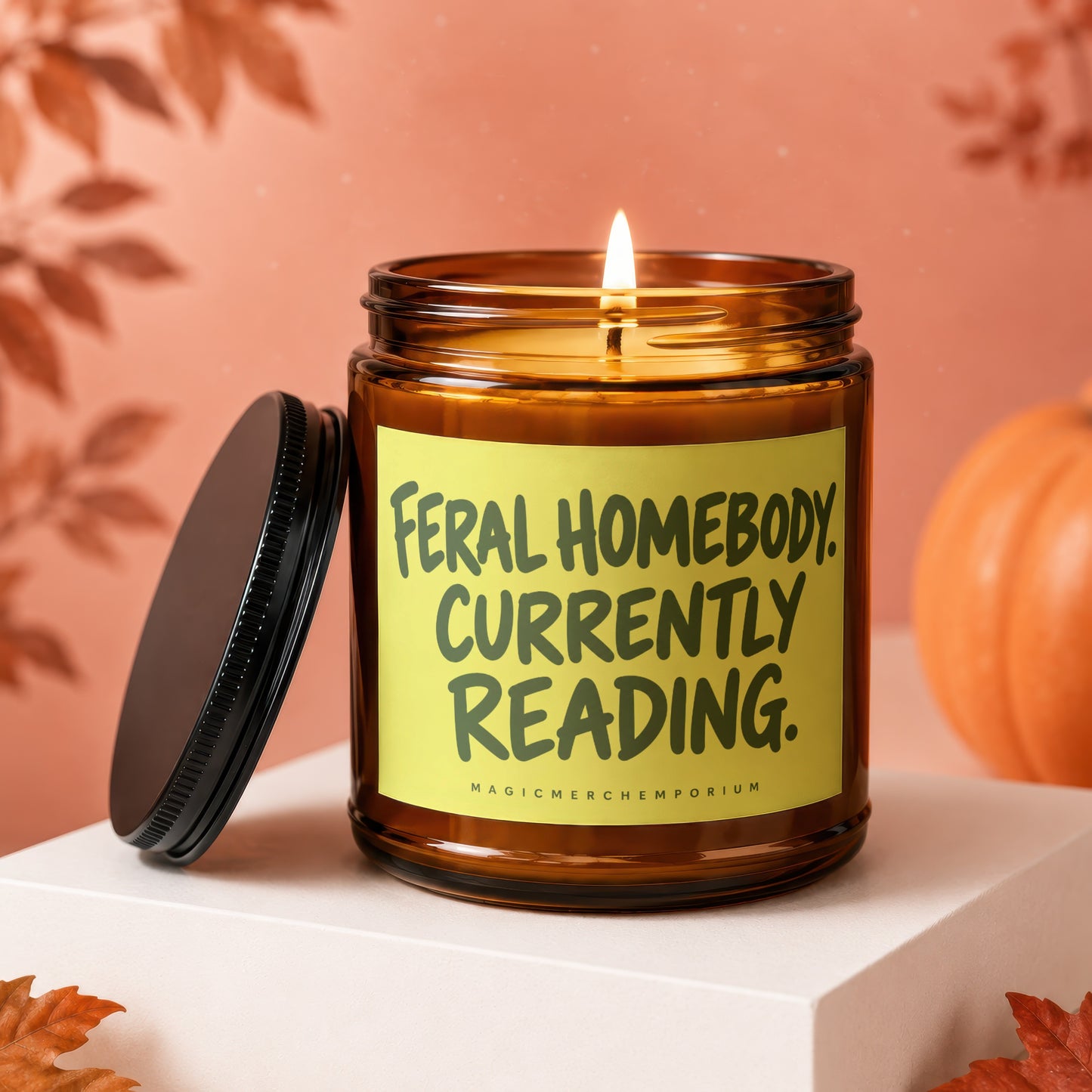 Amber candle with "Feral Homebody Currently Reading." text on a yellow label.