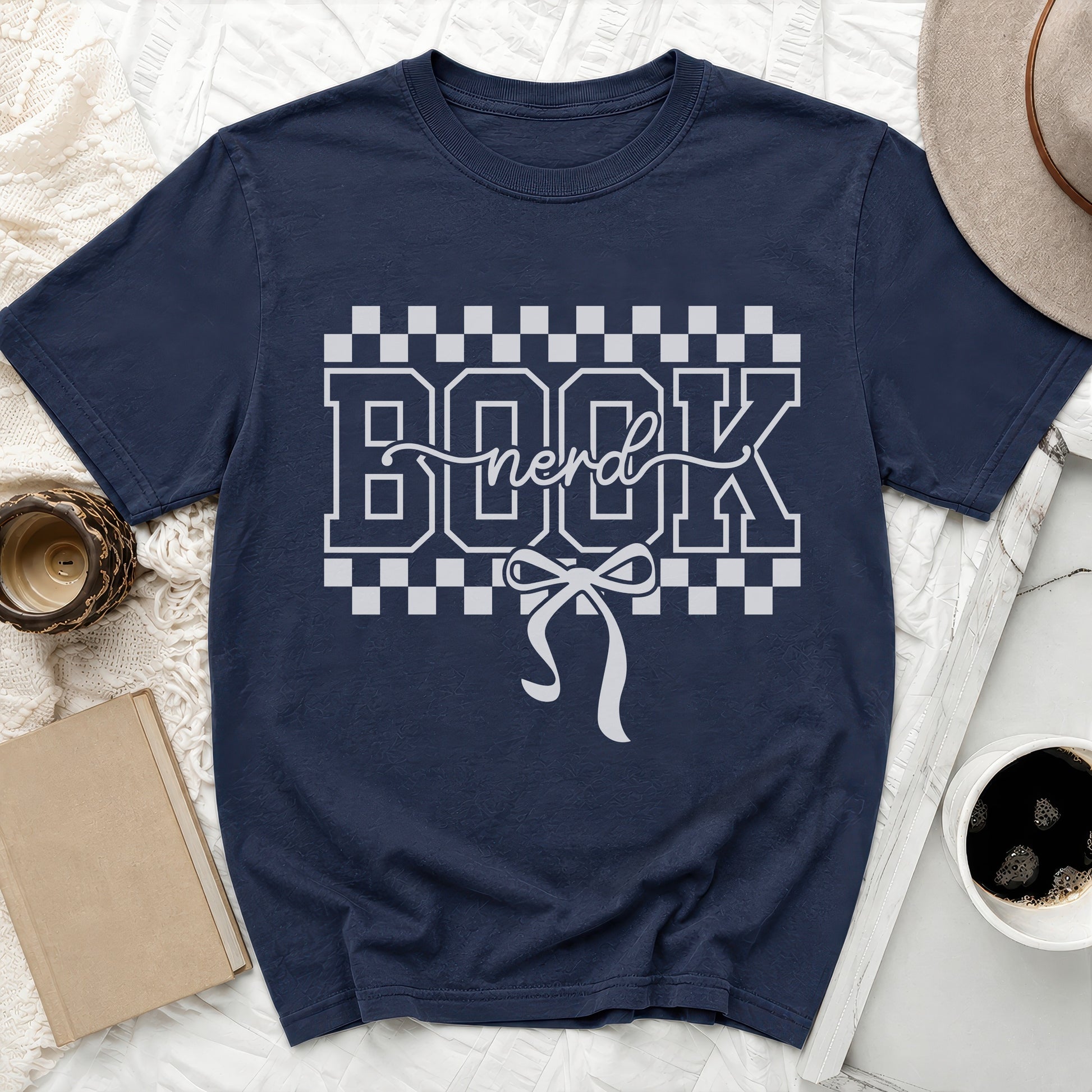 Navy t-shirt with white "BOOK nerd" text and a bow graphic.