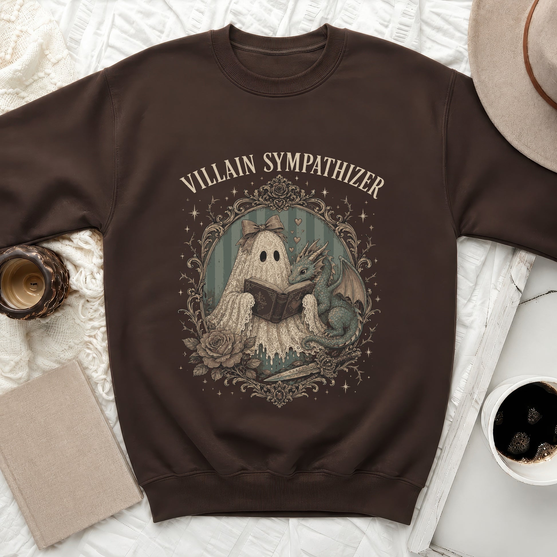 Brown sweatshirt with "Villain Sympathizer" text and ghost and dragon reading a book.