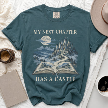 Teal t-shirt with "My Next Chapter Has A Castle" text and castle illustration.