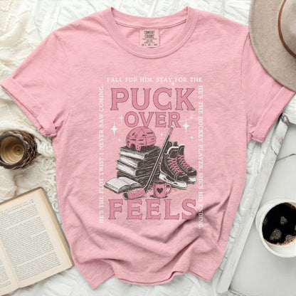 Pink t-shirt with "Puck Over Feels" hockey graphic and text.