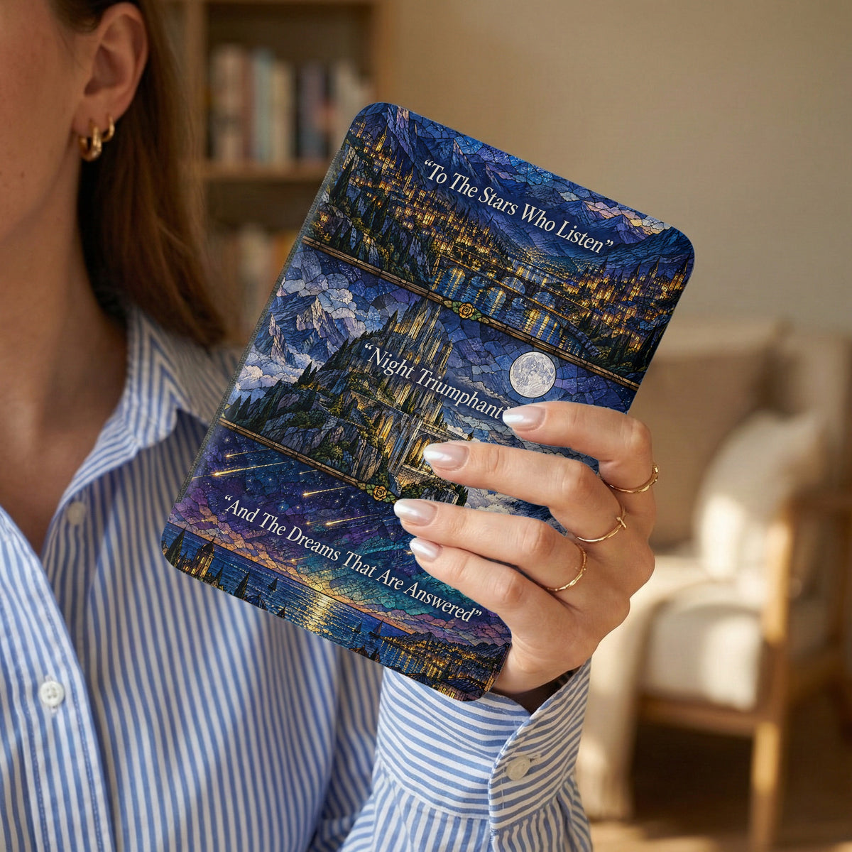 A person holding a blue e-reader case featuring stained-glass style artwork and inspirational quotes.