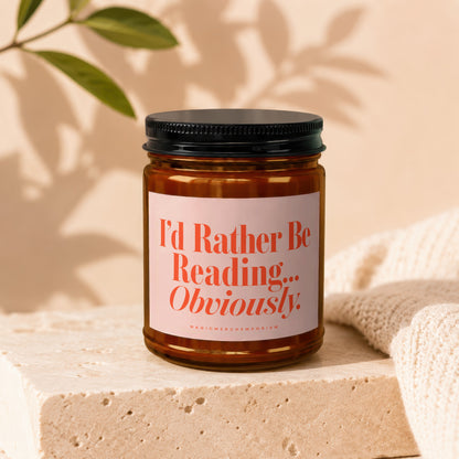 Candle with "I'd Rather Be Reading... Obviously" text on a light pink label.