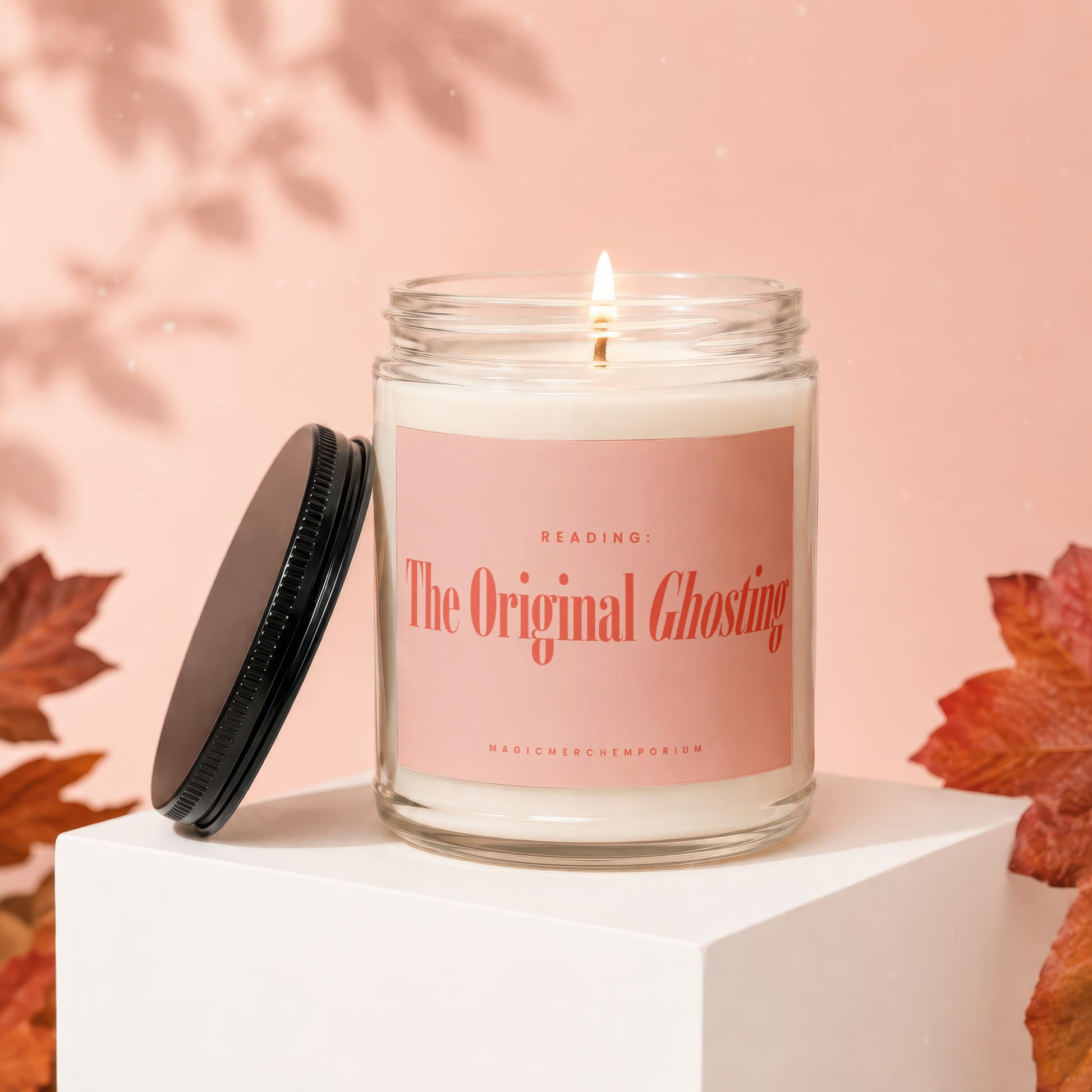 Lit candle in glass jar with pink label reading "The Original Ghosting"