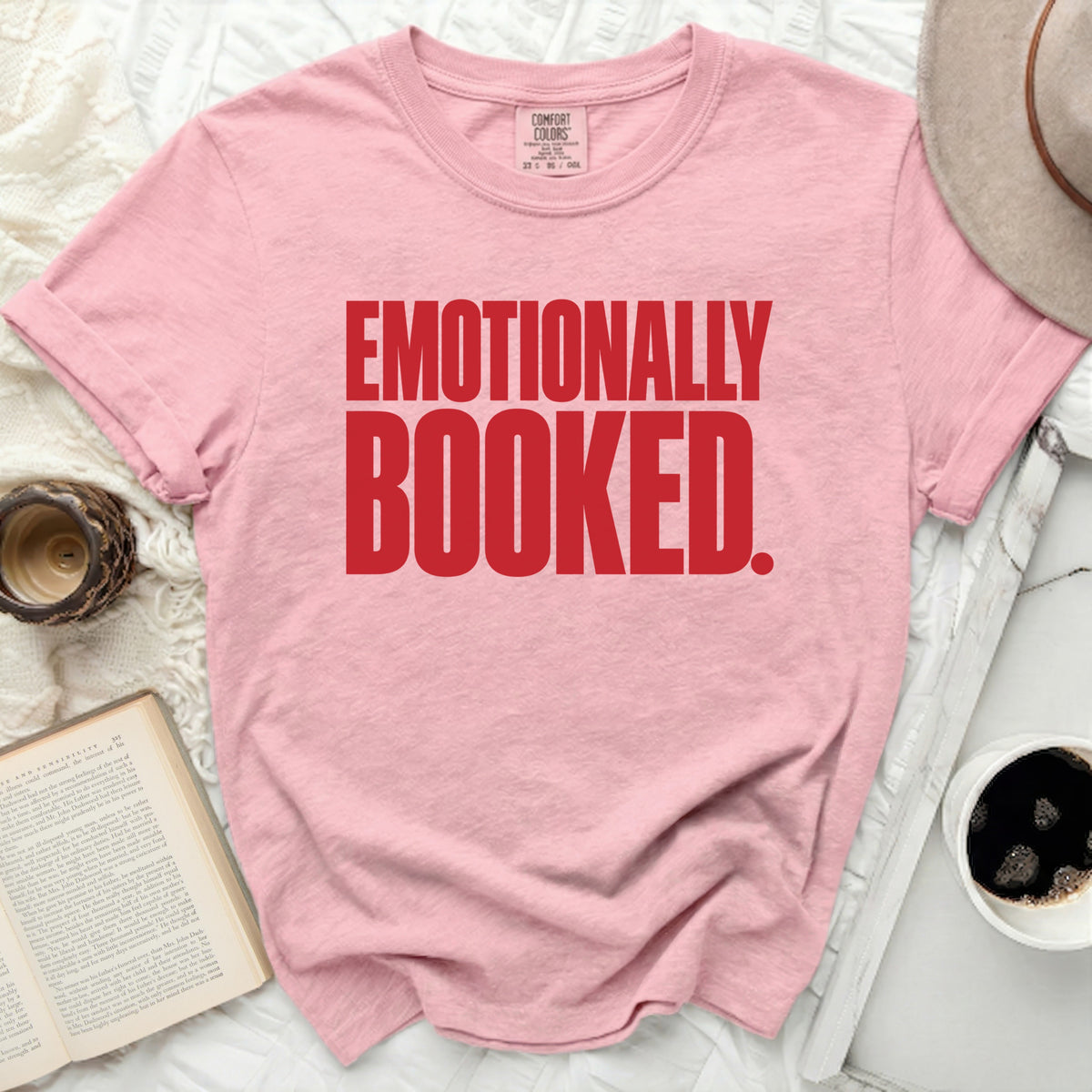 Pink t-shirt with red text "EMOTIONALLY BOOKED."