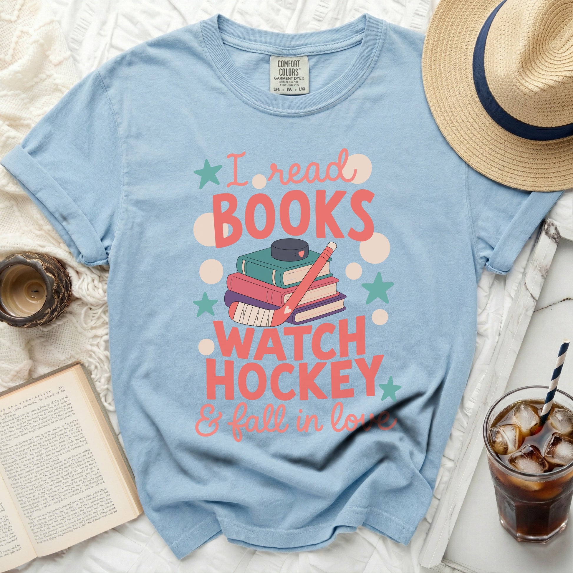 Light blue t-shirt with "I read books, watch hockey & fall in love" graphic.