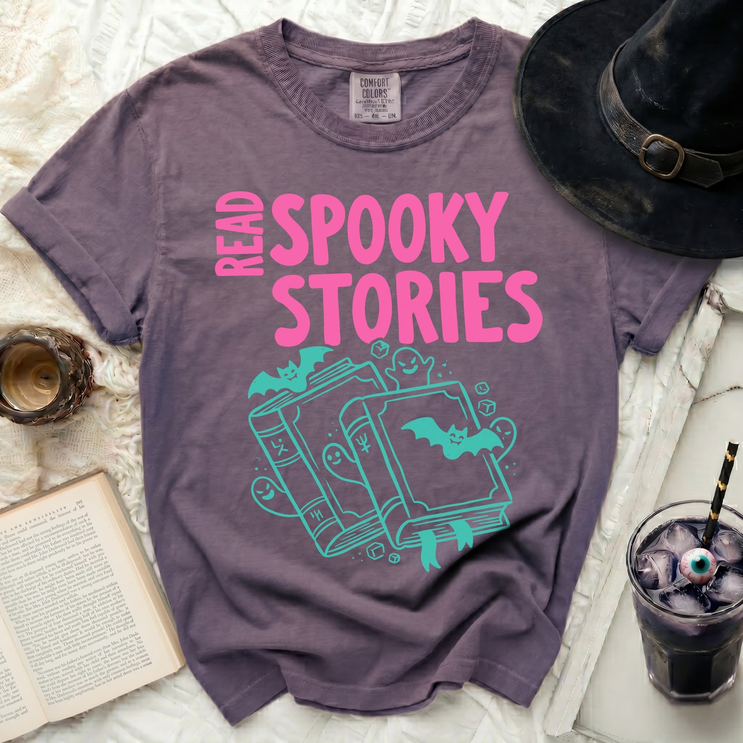 Purple t-shirt with pink "Read Spooky Stories" text and teal Halloween graphics.