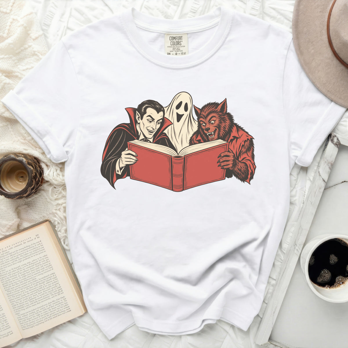 Vampire, ghost, and werewolf reading a red book illustration on a white t-shirt.