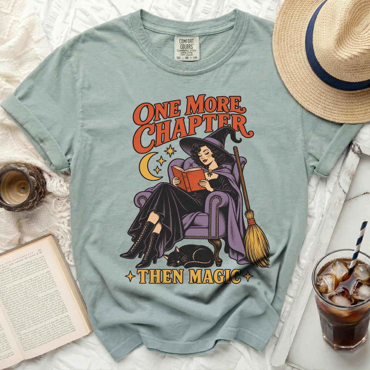 T-shirt graphic with witch reading, cat, and text "ONE MORE CHAPTER THEN MAGIC."