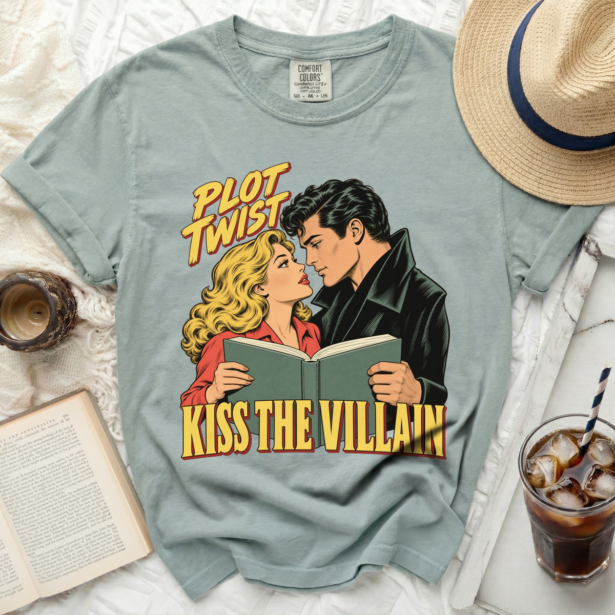 T-shirt with "Plot Twist Kiss the Villain" graphic of a couple reading a book.