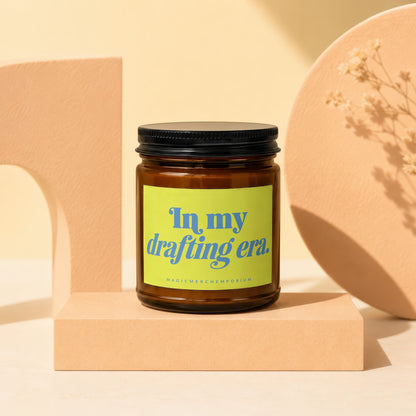 Brown candle with black lid and neon green label reading "In my drafting era."