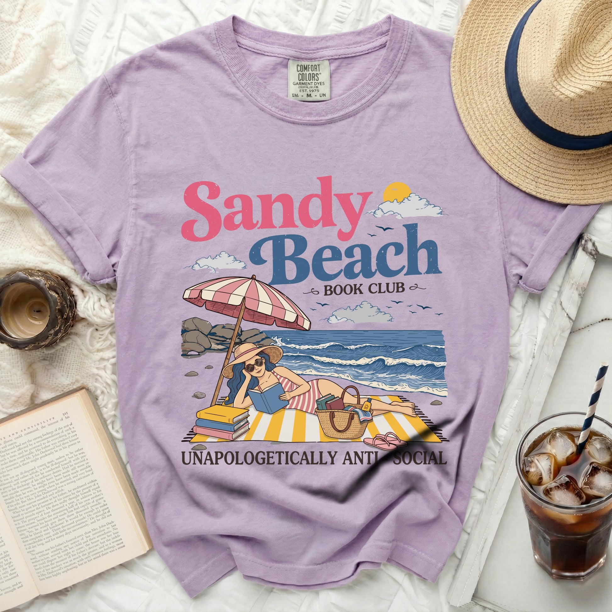 Purple t-shirt with "Sandy Beach Book Club" graphic and woman reading.