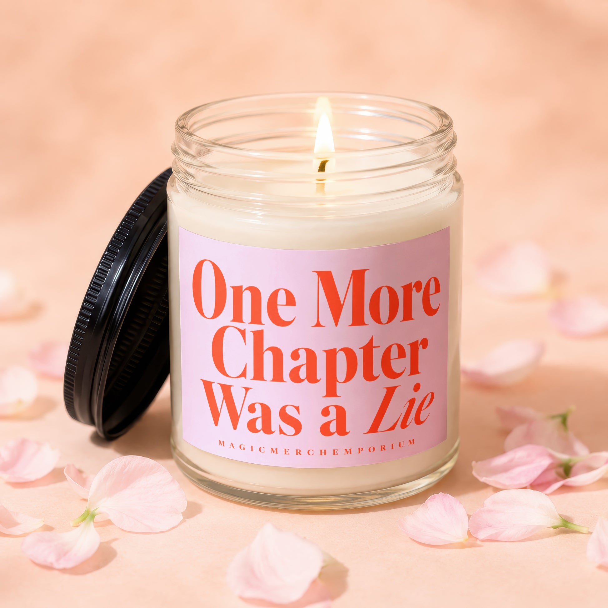 Candle with lit wick, pink label reading "One More Chapter Was a Lie."