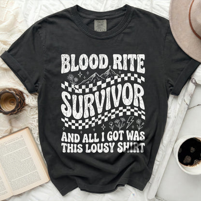 Black t-shirt with "Blood Rite Survivor" text, mountains, and checkered pattern.
