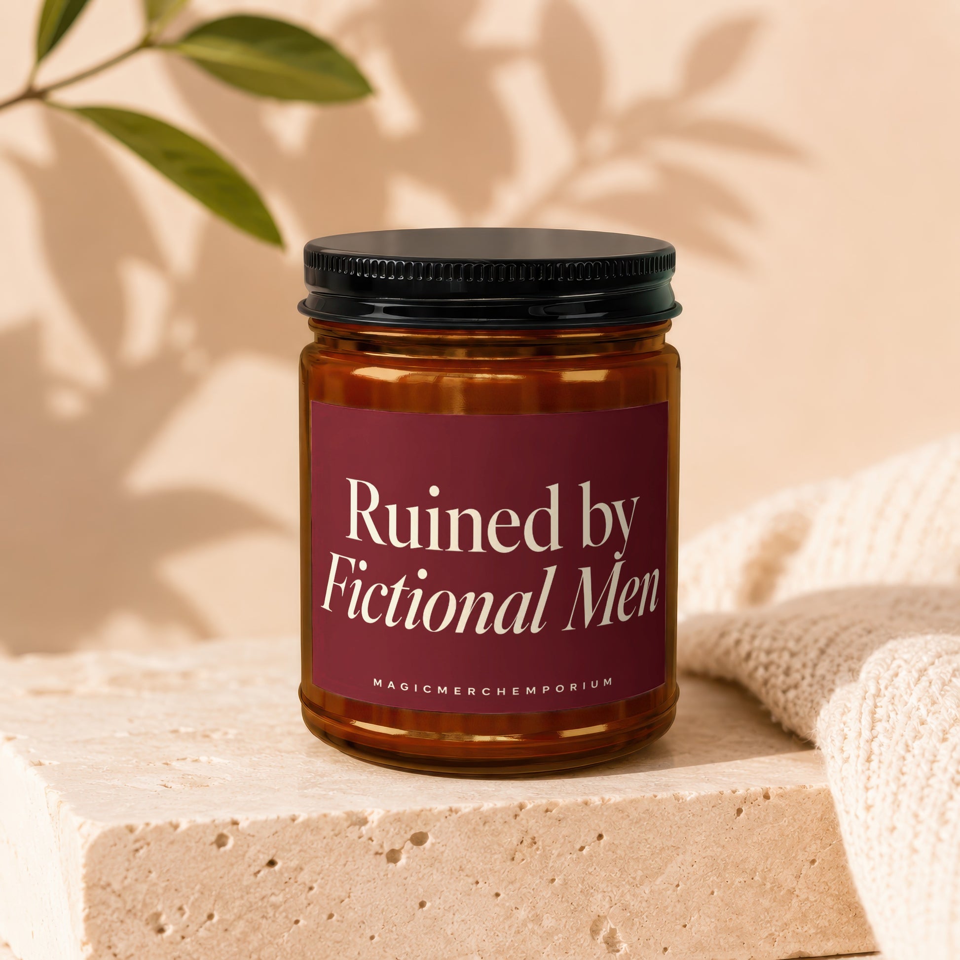 Amber glass candle with maroon label reading "Ruined by Fictional Men."