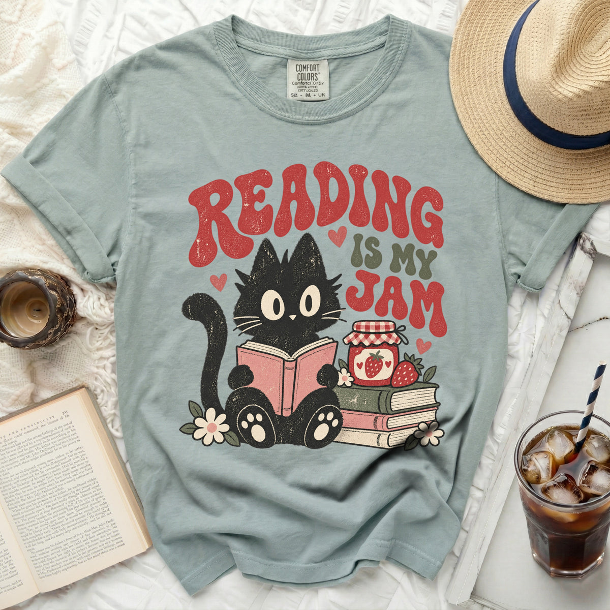 Light blue t-shirt with black cat reading, "Reading is My Jam" text, and strawberry jam.