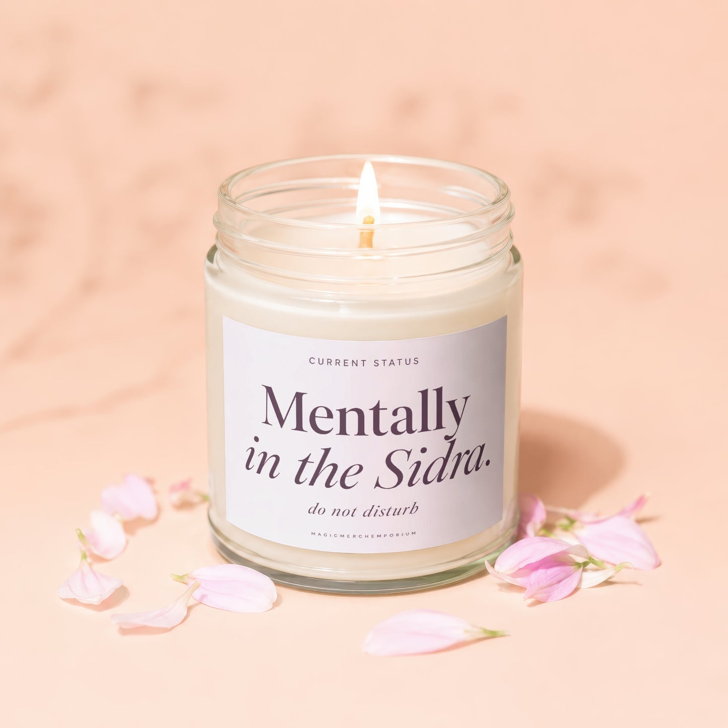 Candle with text "Mentally in the Sidra. do not disturb." surrounded by petals.