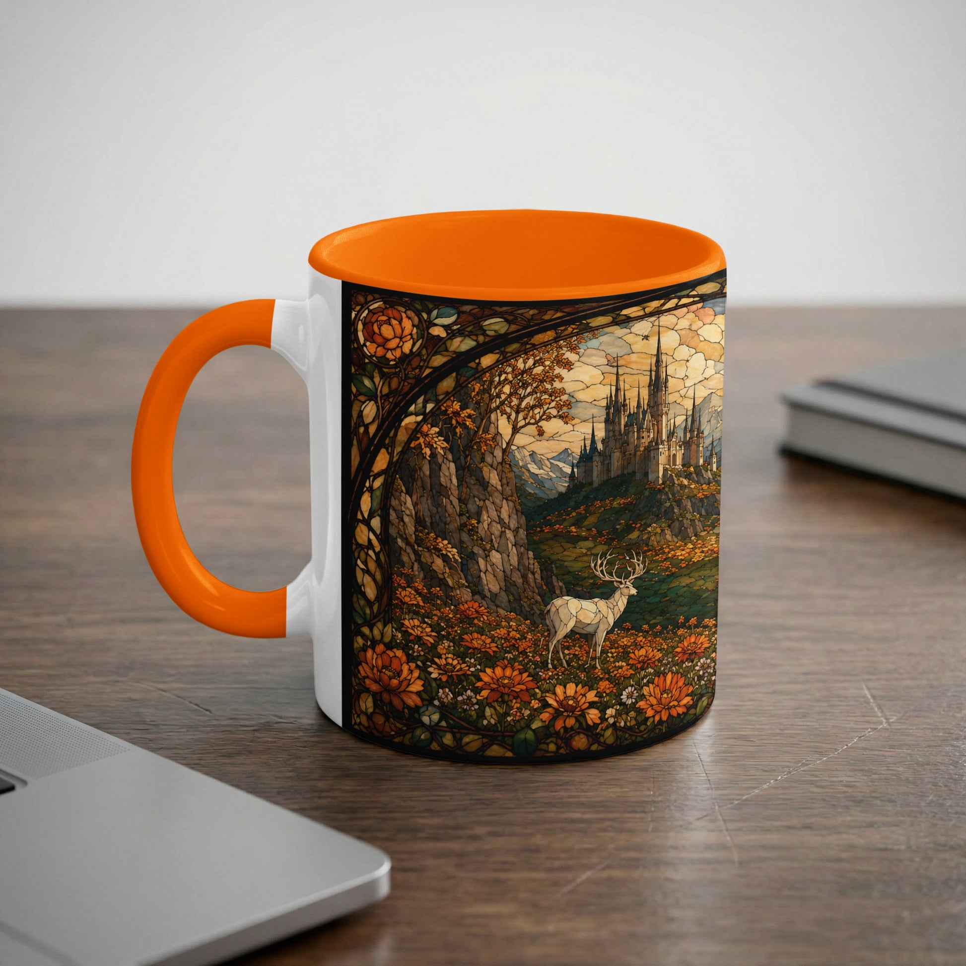 White mug with orange handle featuring a stained-glass design of a castle and stag.