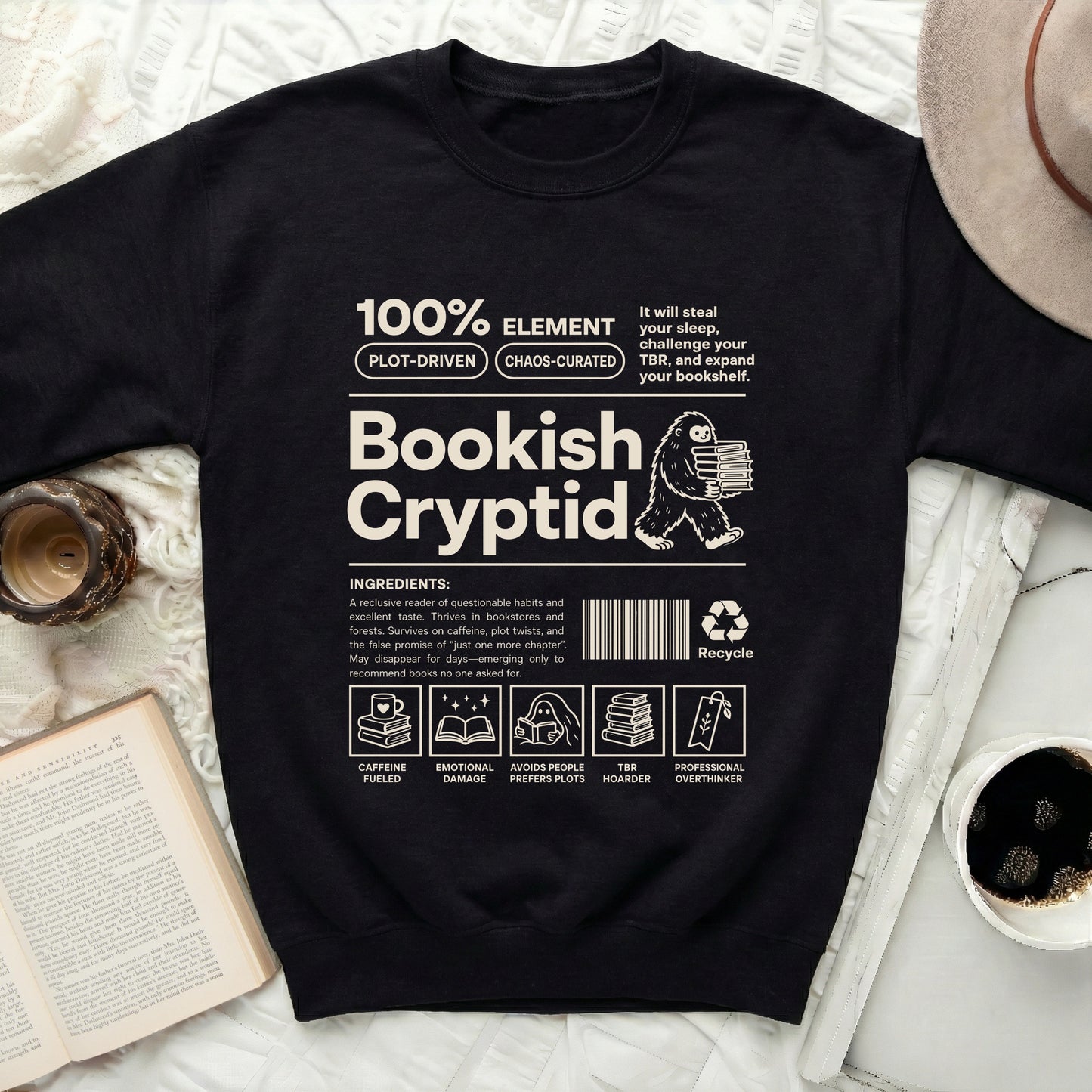 Bookish Cryptid crewneck sweatshirt with graphic of Bigfoot holding books and reading-themed ingredients.
