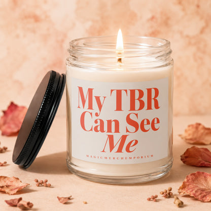 Glass candle labeled "My TBR Can See Me" with a lit wick.
