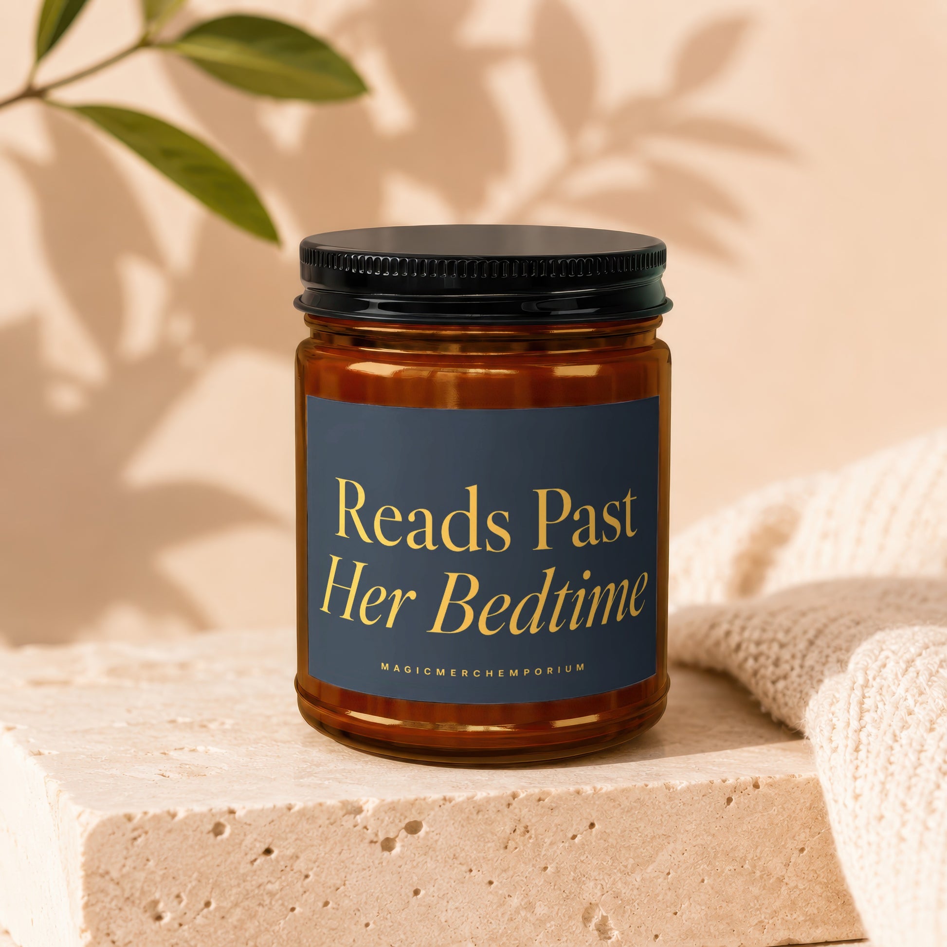 Amber jar candle with "Reads Past Her Bedtime" text on dark blue label.