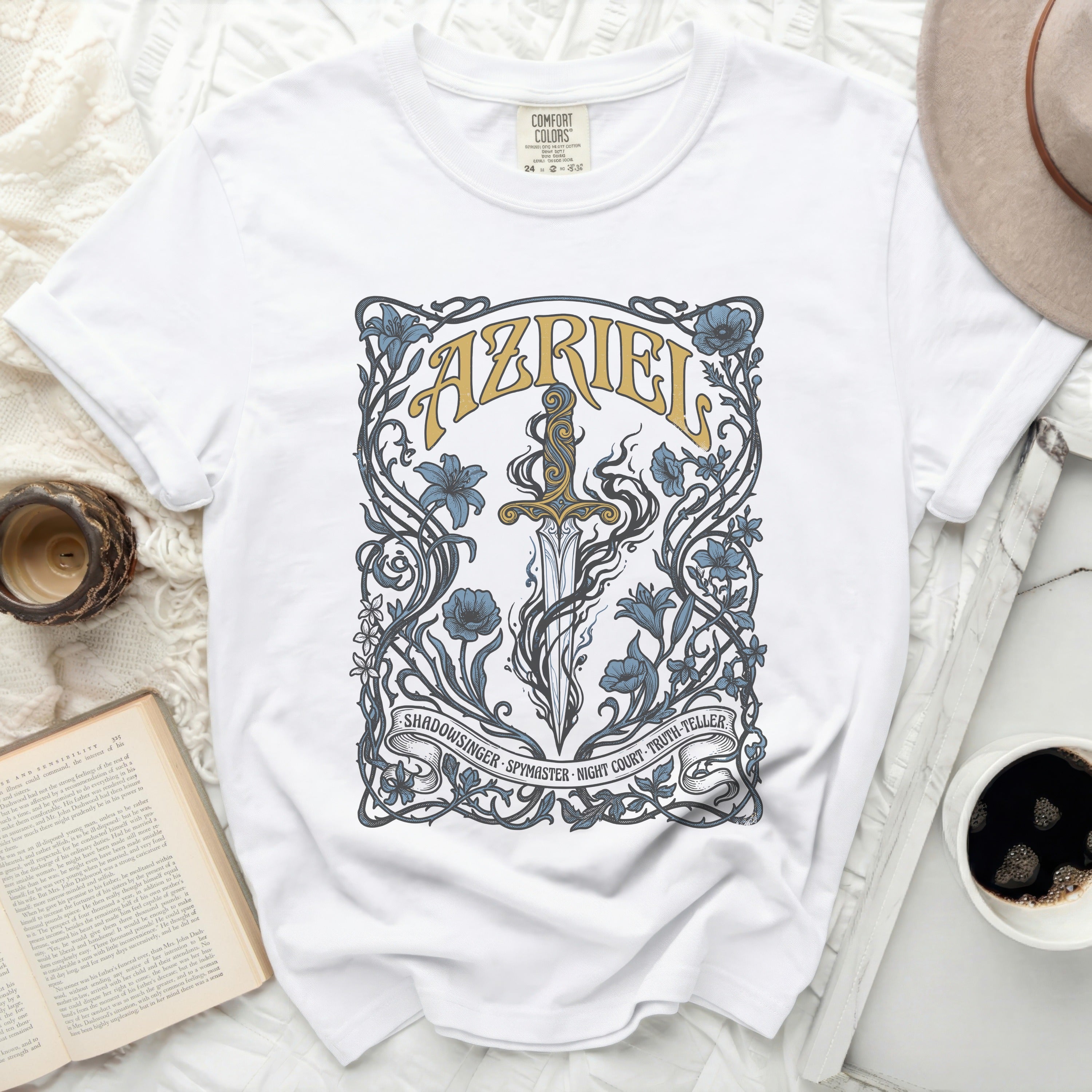 White t-shirt with ornate blue floral design and text 