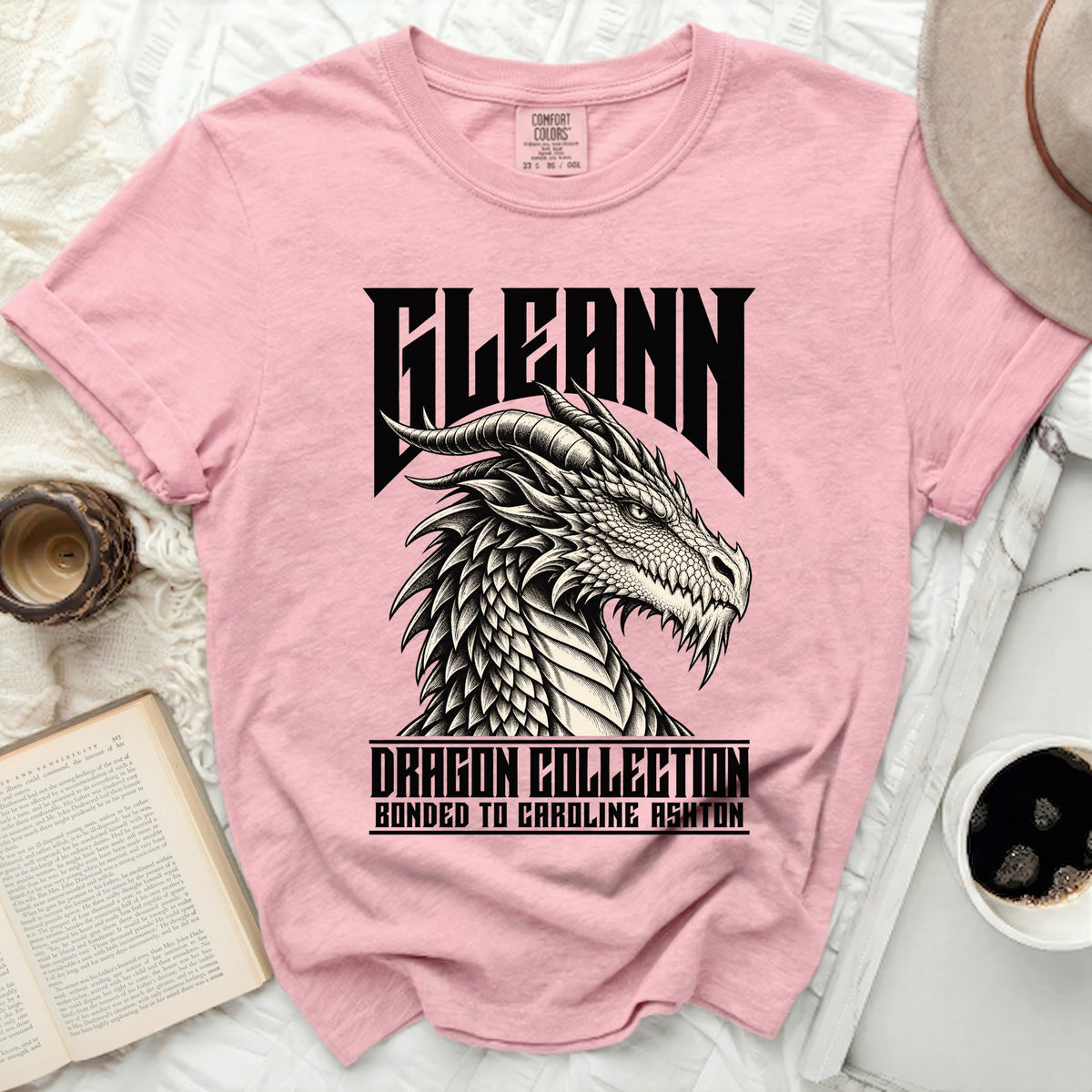 Pink t-shirt with a black and white dragon graphic and text "KLEANN DRAGON COLLECTION BONDED TO CAROLINE ASHTON".