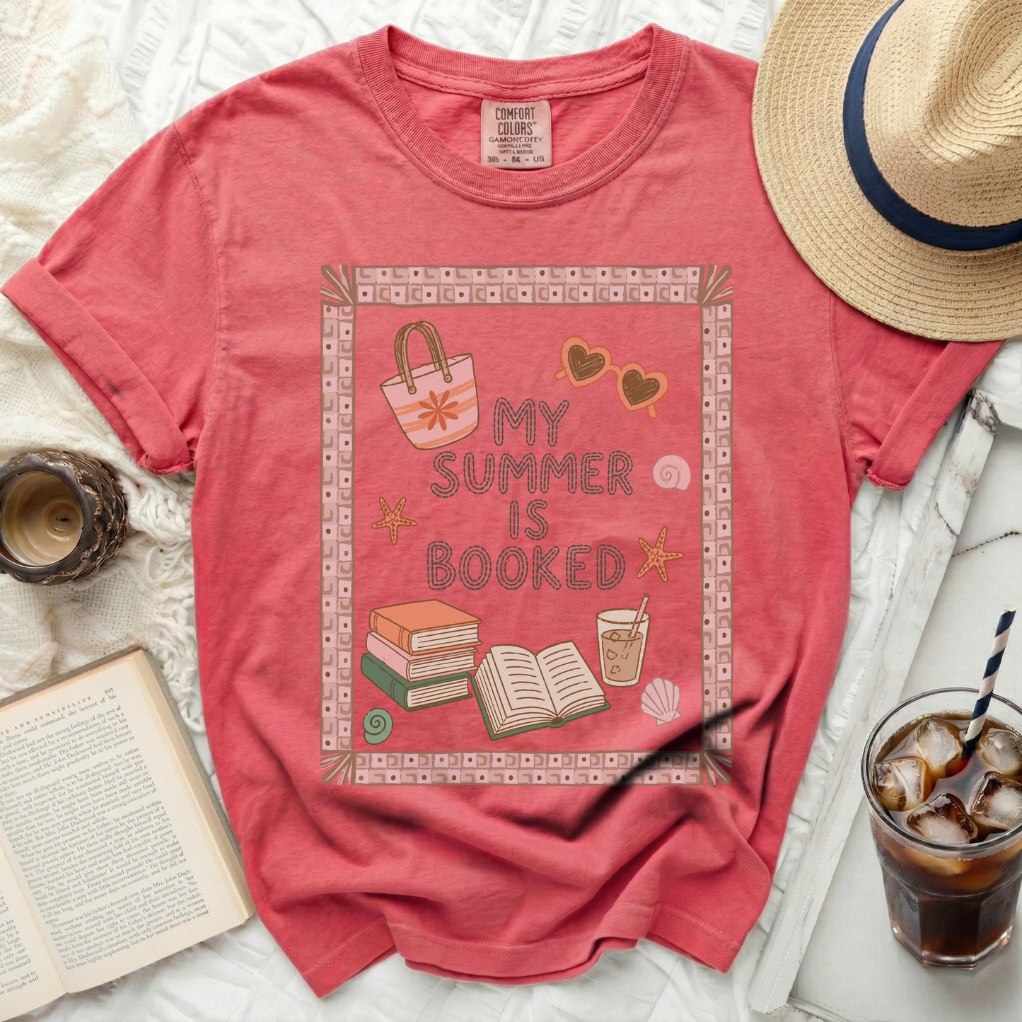 Pink t-shirt with "My Summer is Booked" text and beach motifs.