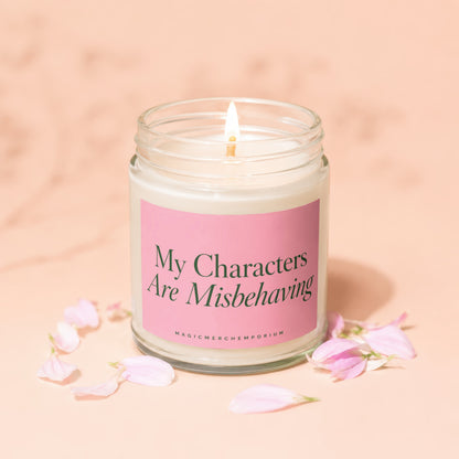 Jar candle with lit flame and pink label reading "My Characters Are Misbehaving".