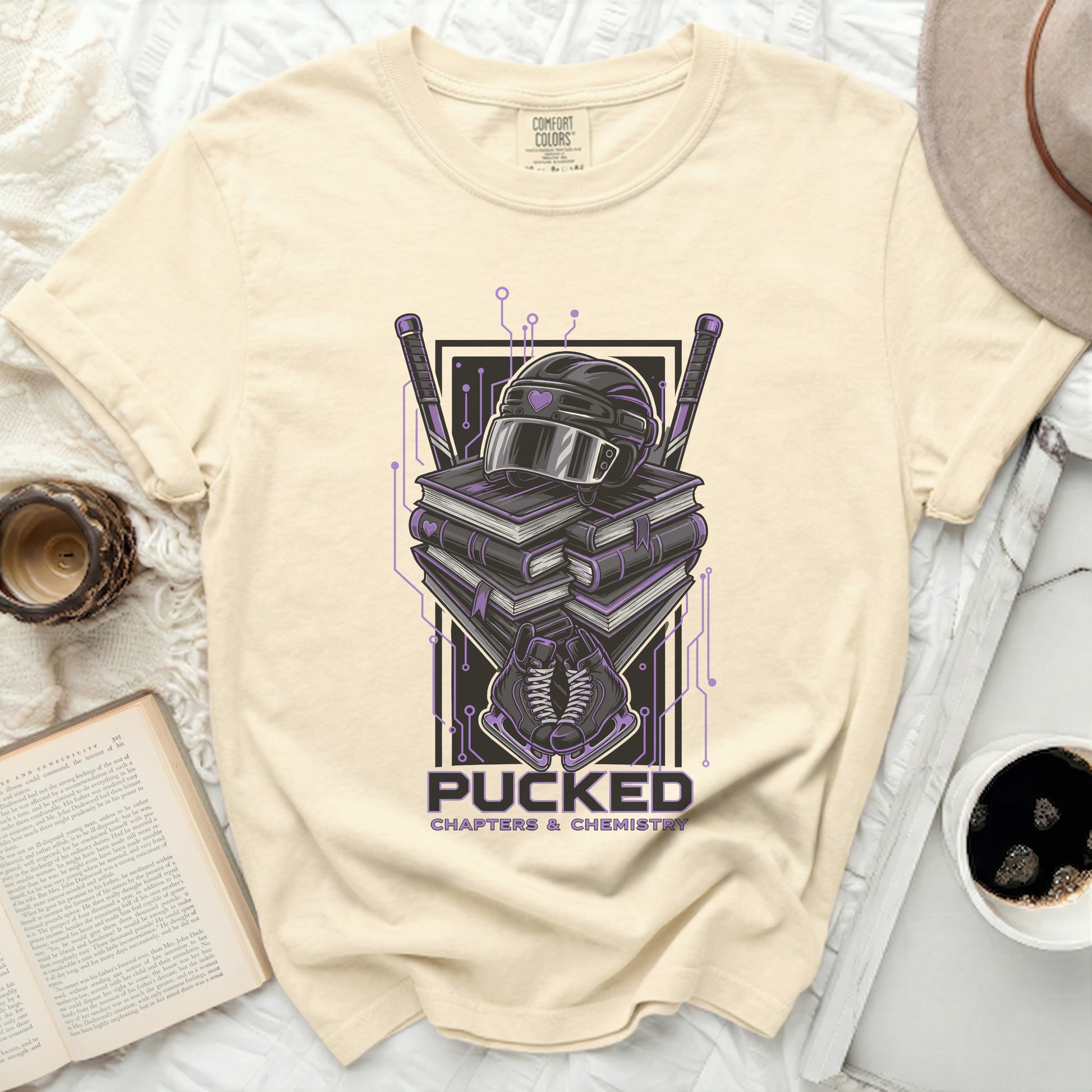 Cream t-shirt with hockey helmet, puck, and books graphic.