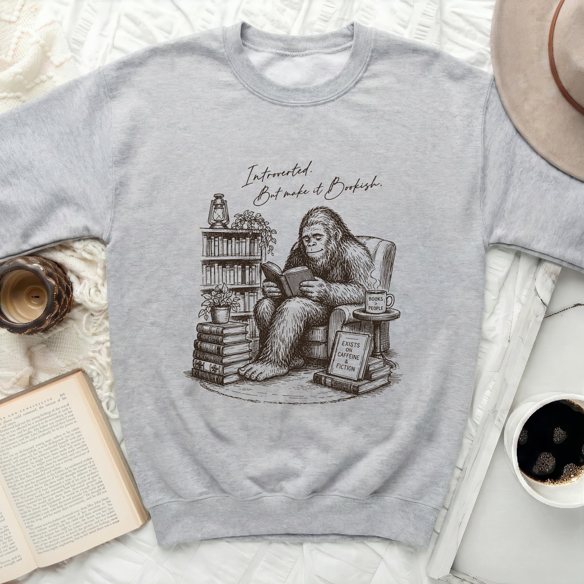 Crew neck sweatshirt with a sketch of Bigfoot reading books and a "Bookish" quote.