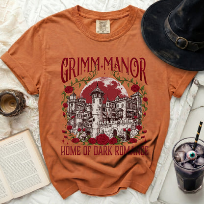 Orange t-shirt with "Grimm Manor Home of Dark Romance" castle graphic.